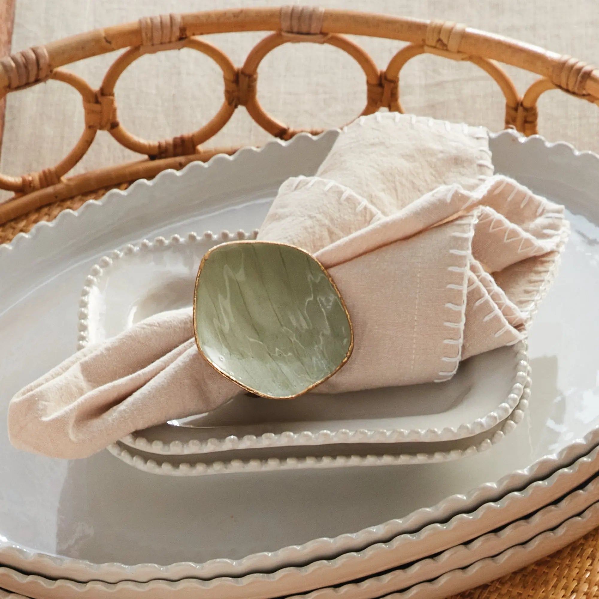 Complete table setting featuring a folded cloth napkin and a stylish ring