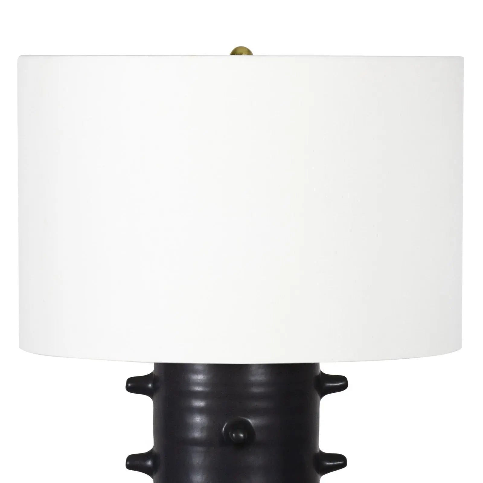 Table lamp with a black textured base and white shade on a white background
