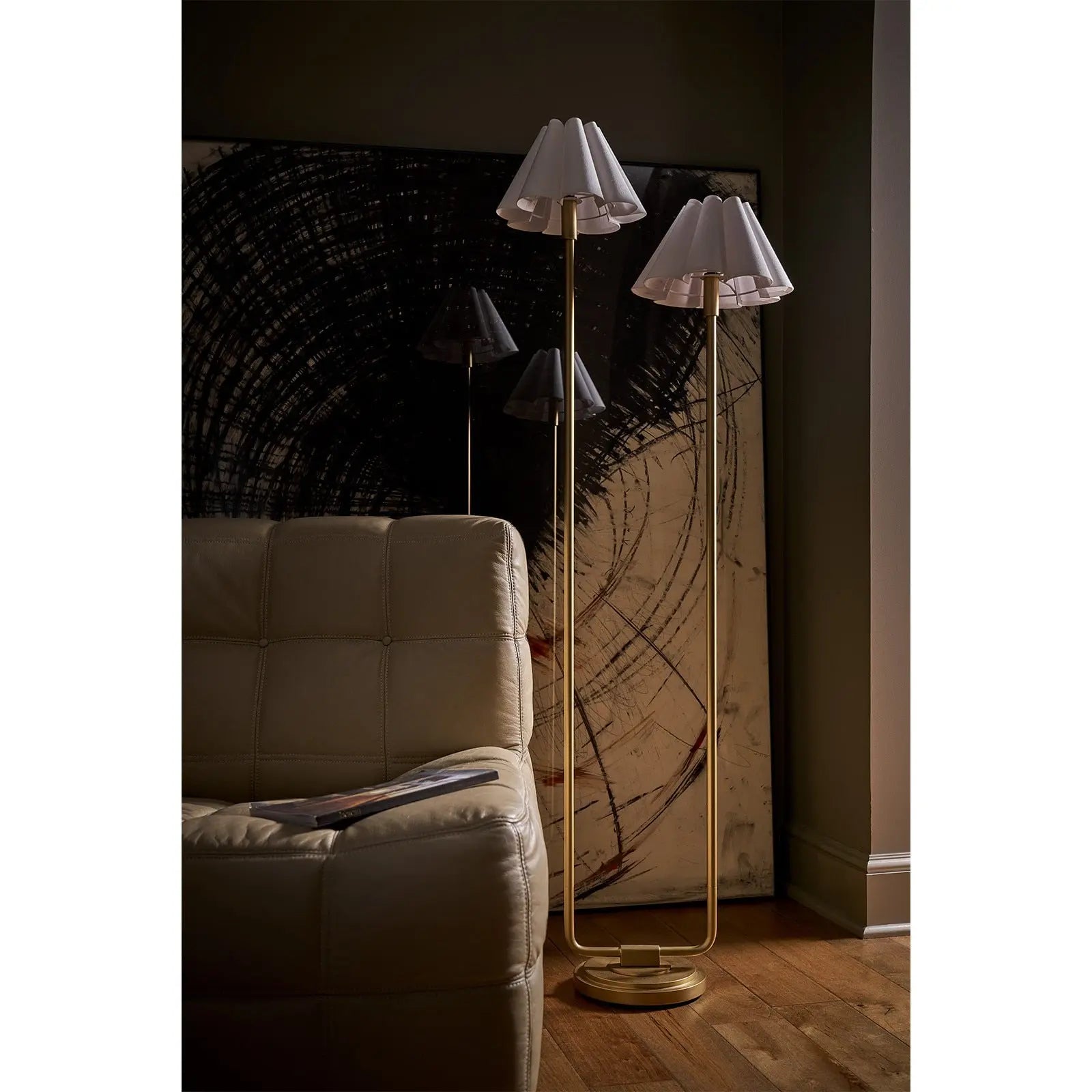 Two floor lamps with white lampshades in a dimly lit room.