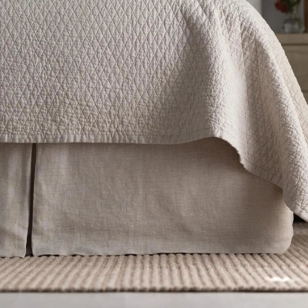 Dawn Tailored Bed Skirt in cream, close-up on a bed frame