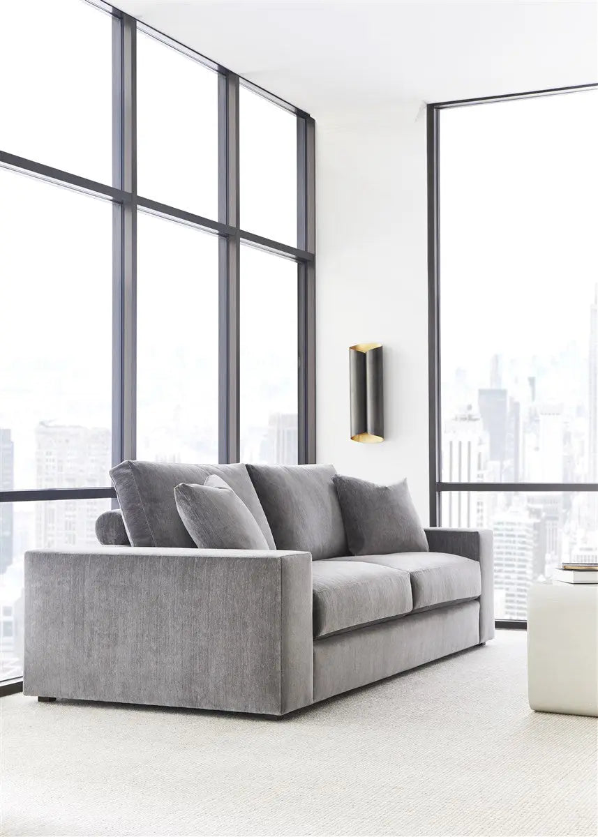 Gray sofa in a modern living room with large windows and cityscape view