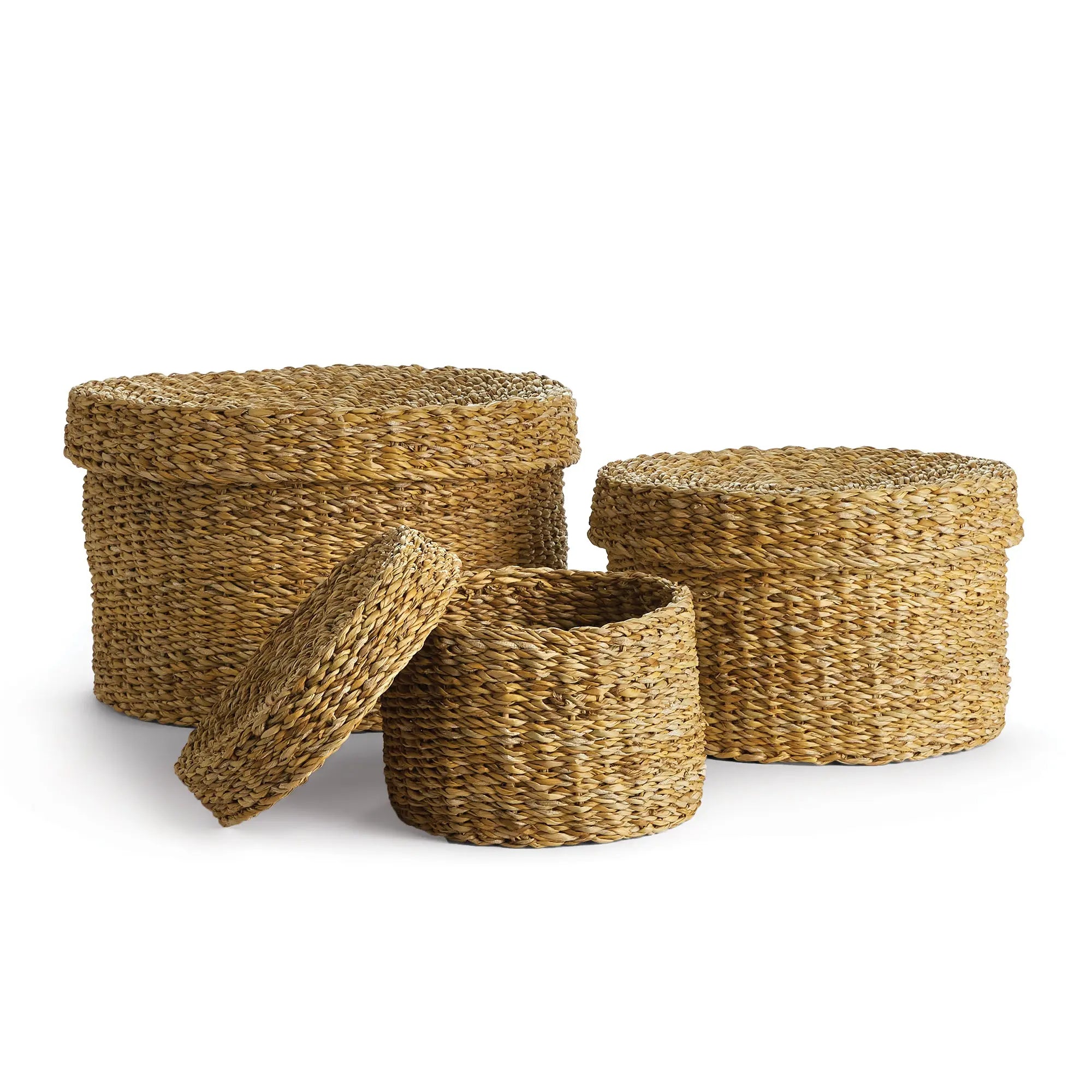 Set of three woven baskets with lids on a white background