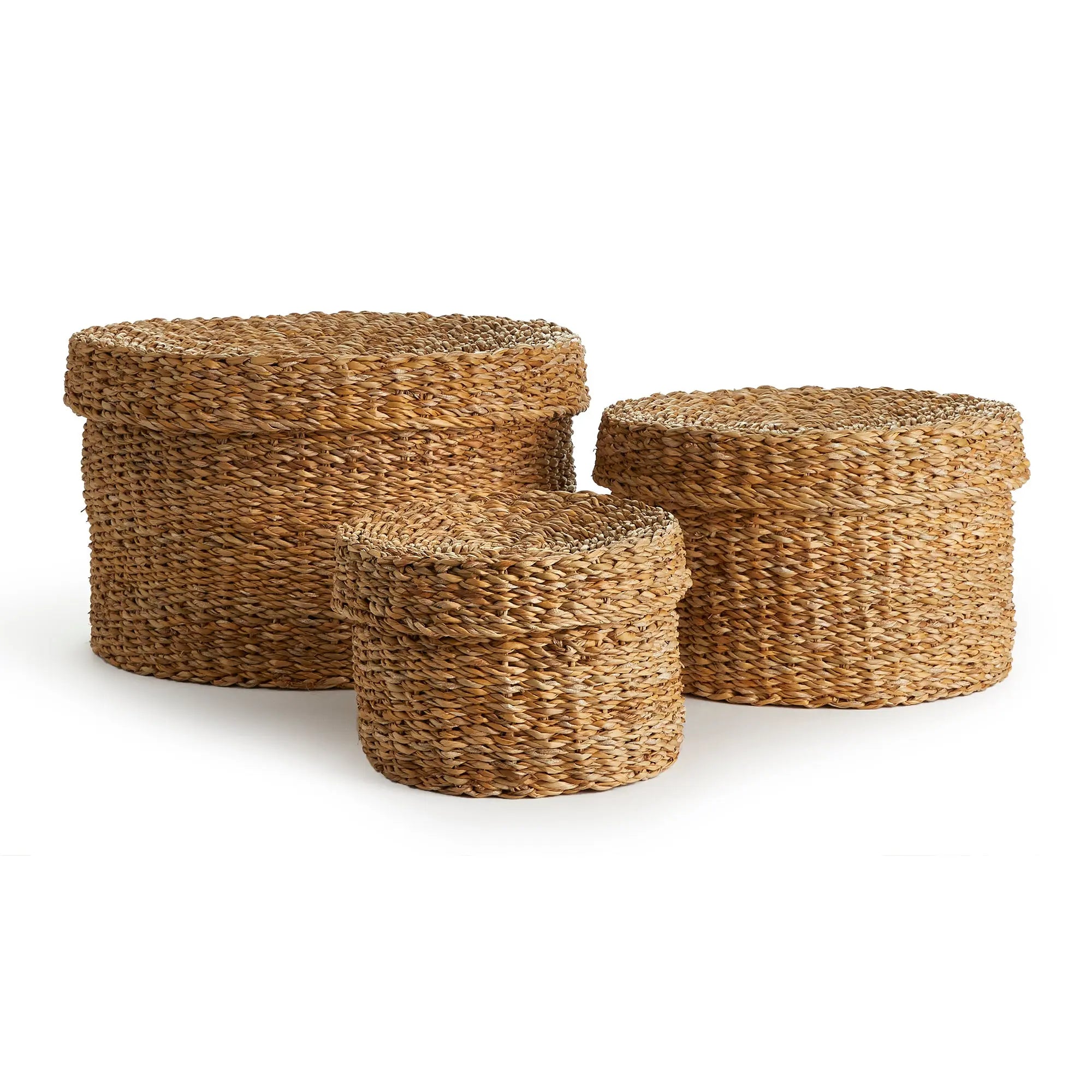 Set of three woven storage boxes with lids on a white background