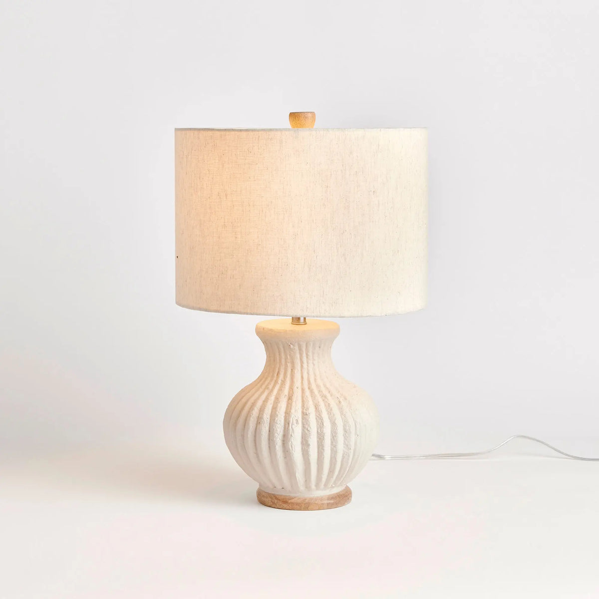 Margot lamp on a wood surface with linen drum shade