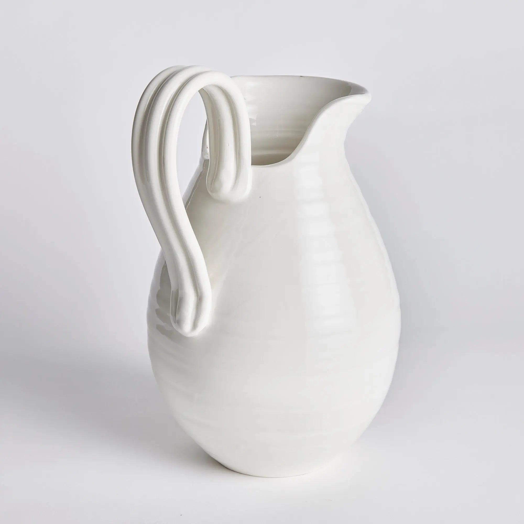 White ceramic pitcher on a light gray background