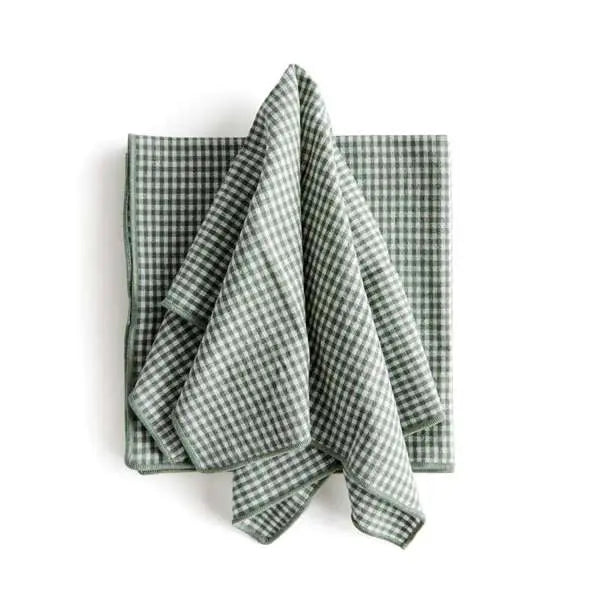 Set of four Viola Dinner Napkins made from soft, verdant green cotton, folded and tied with a grosgrain ribbon.