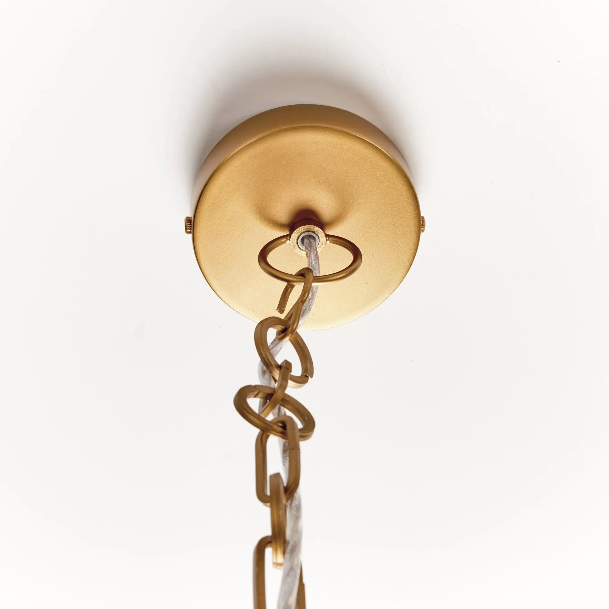 Close-up of a gold ceiling light fixture with chain on a white background