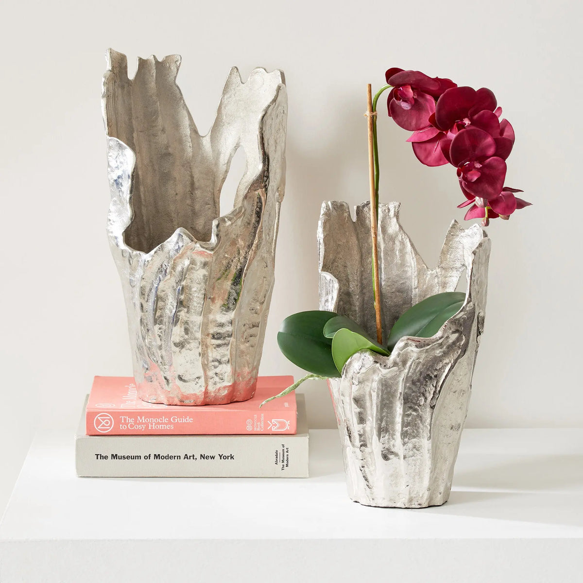 Arbre silver vase with an orchid on a stack of books