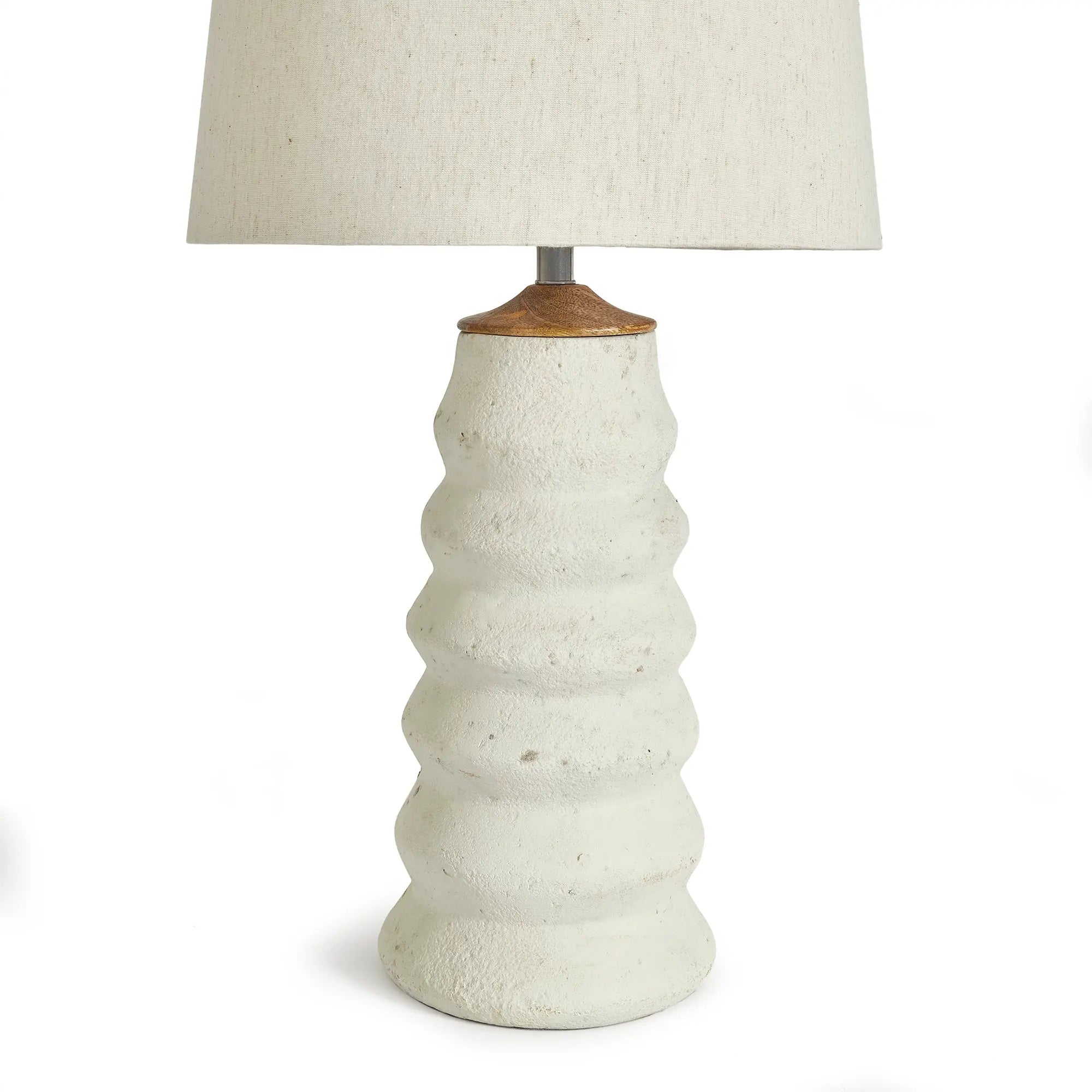 Adria Table Lamp with a textured, pitted, warm white ecomix base and a cream-colored tapered lamp shade. The lamp is shown from the front against a neutral background.