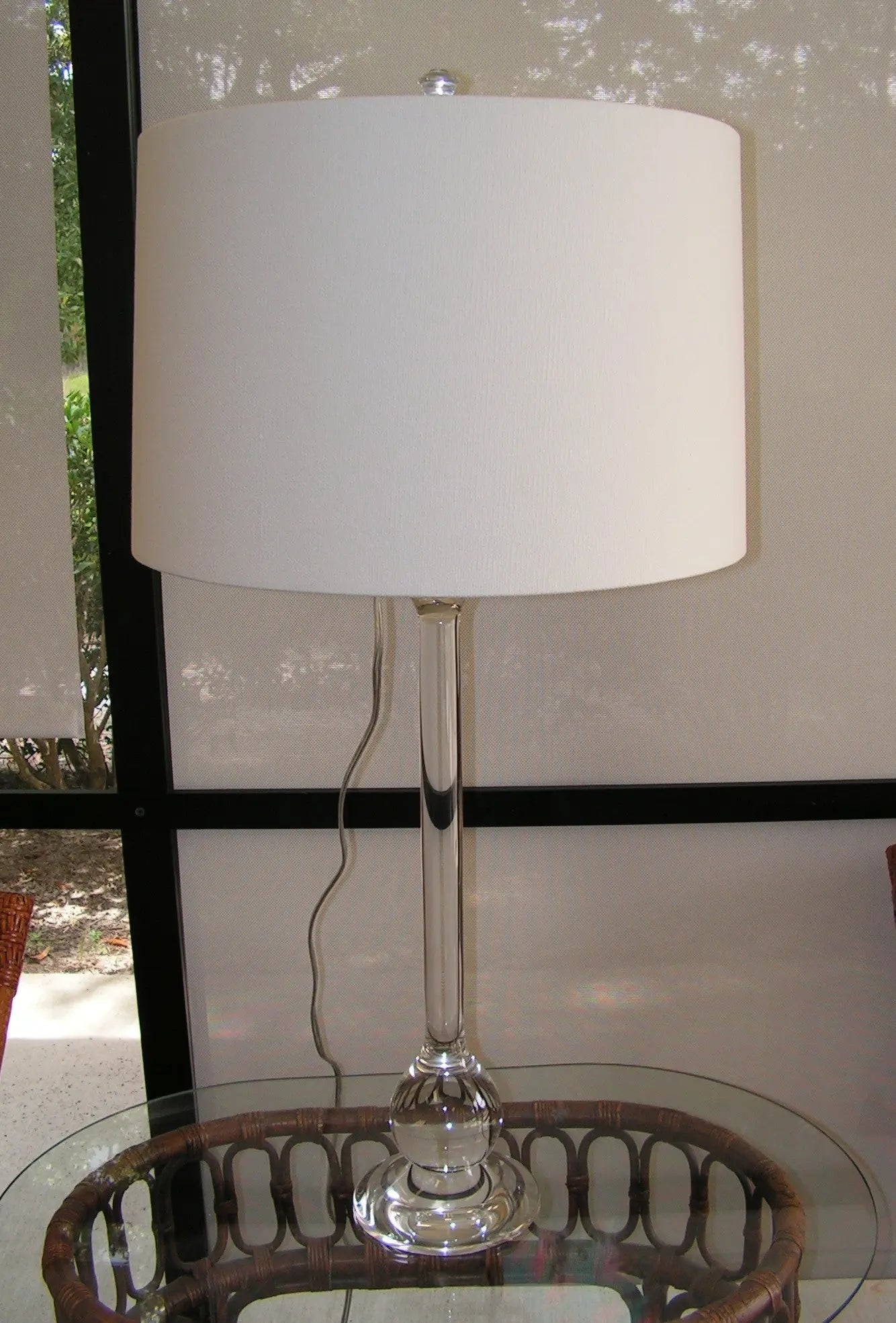 Ponte solid lead crystal table lamp with diamond-cut faceted base and cream-colored fabric drum shade, set on a console table.