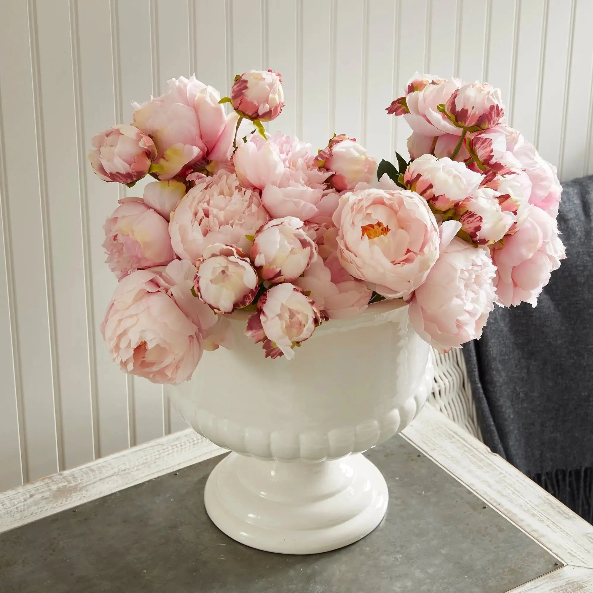 Modern indoor pots and footed planters styled with lush greenery.