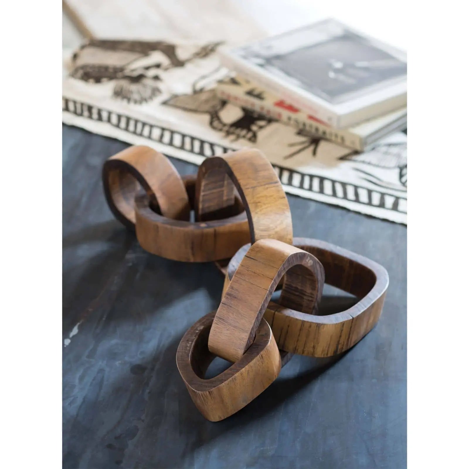 Wooden bracelet on a dark surface with a magazine in the background