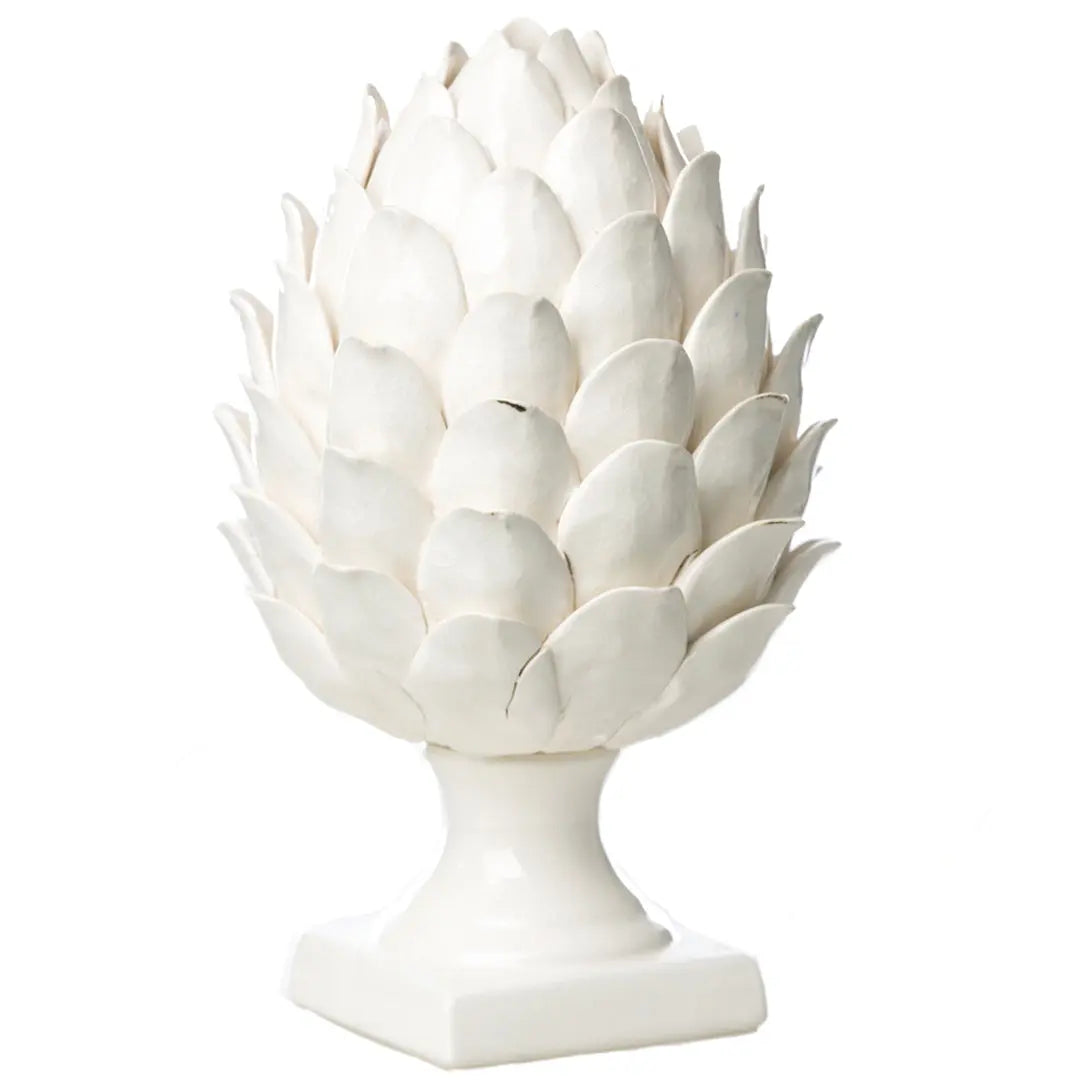 A white glazed ceramic artichoke on a footed base, showcasing its intricate design and crisp white color against a neutral background.