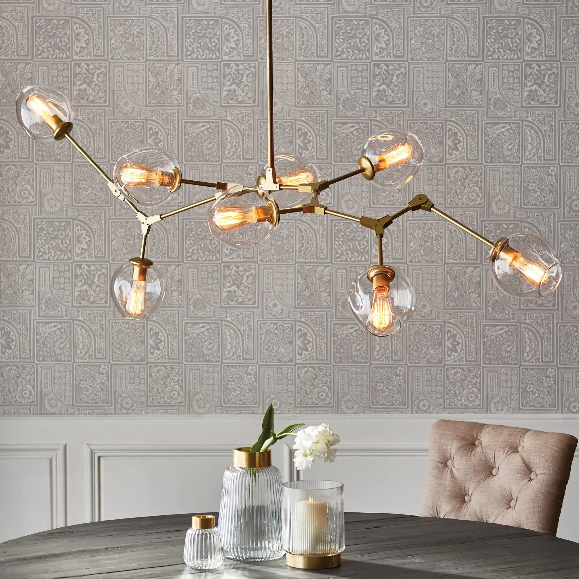 Modern Daniella globe chandelier in antique brass with adjustable arms and glass globes
