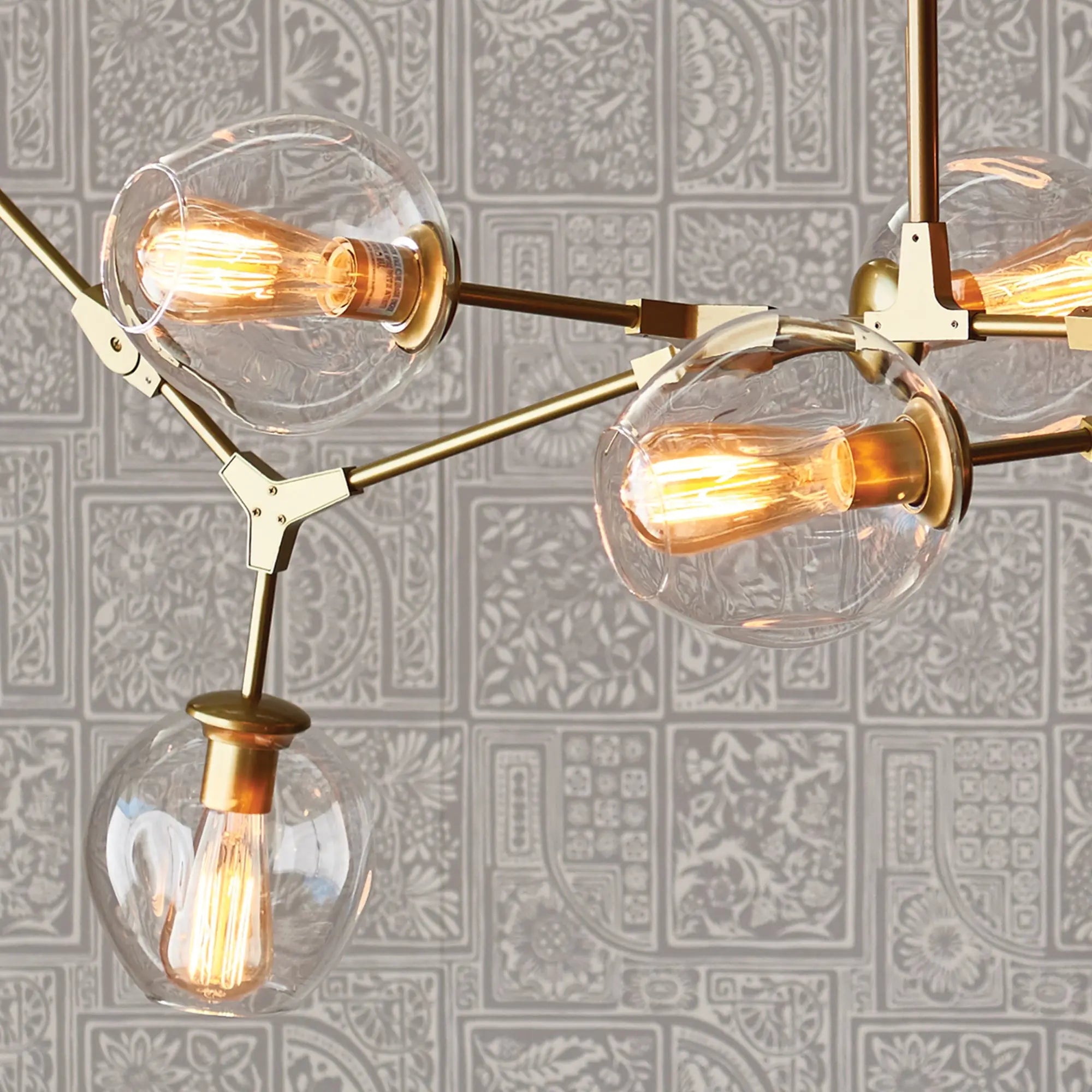 Modern Daniella globe chandelier in antique brass with adjustable arms and glass globes
