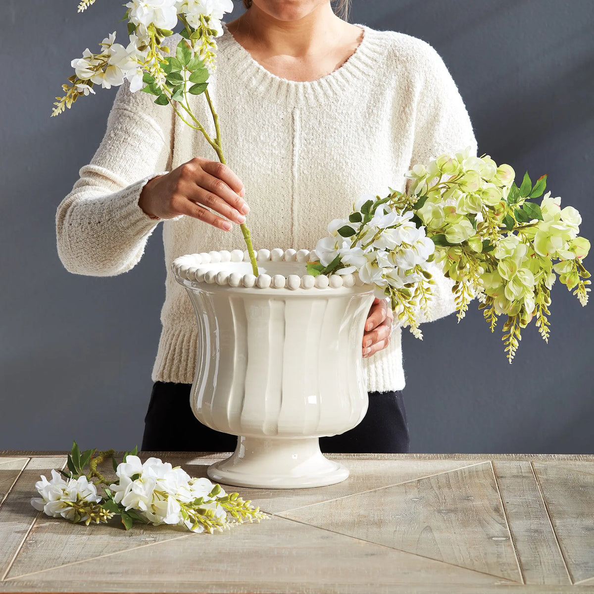 Woman arranging flowers in the Coletta Petite vase