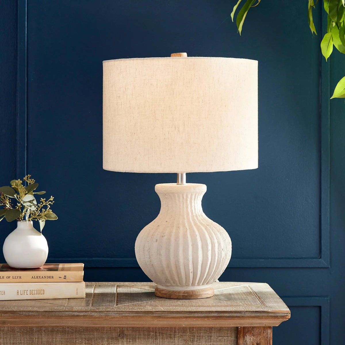 Margot lamp styled on a wood table against a navy wall