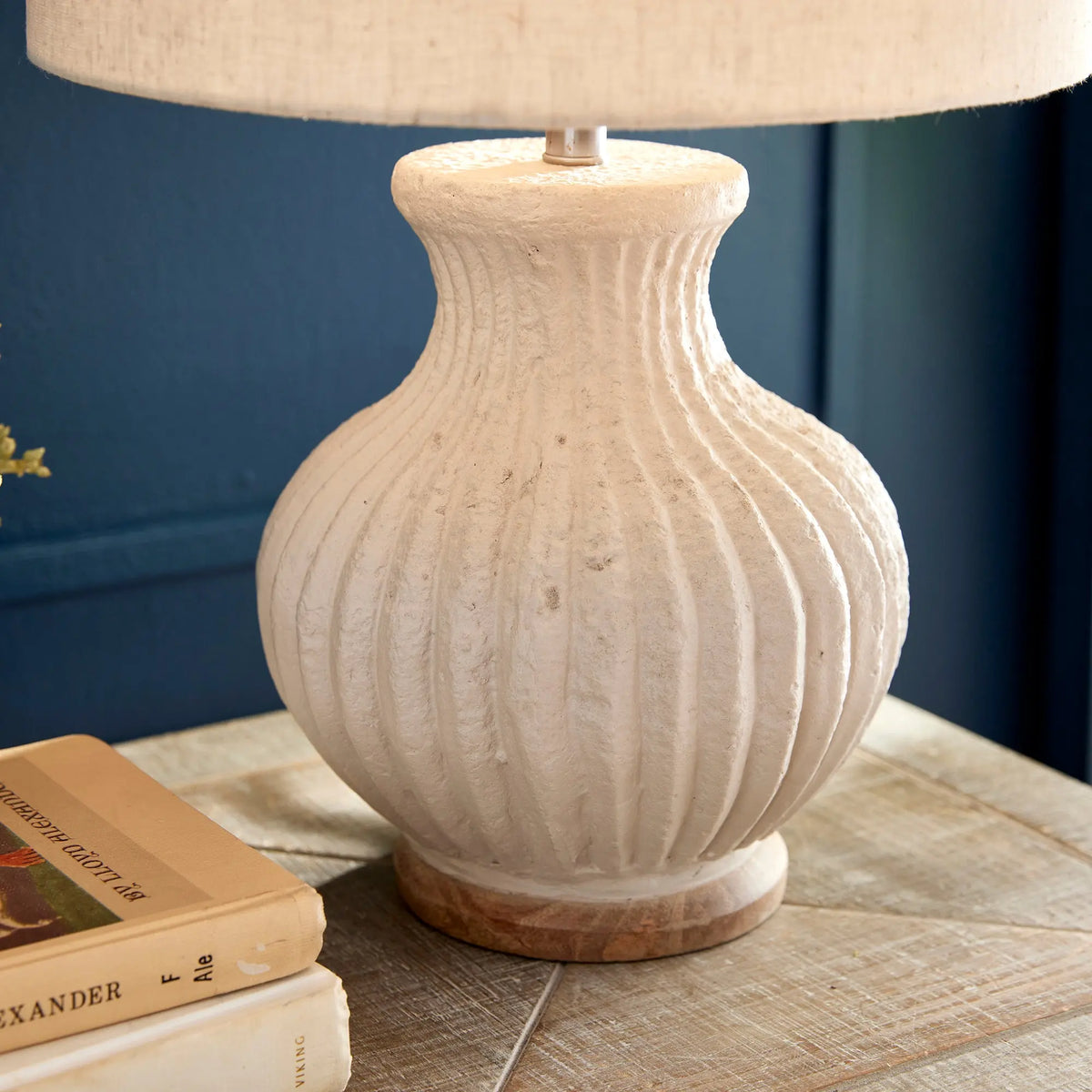 Margot lamp styled on a console with books against a blue wall