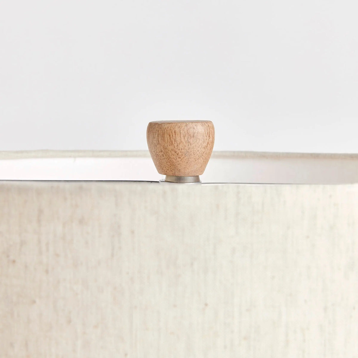 Close-up of the lamp's wood finial and shade top