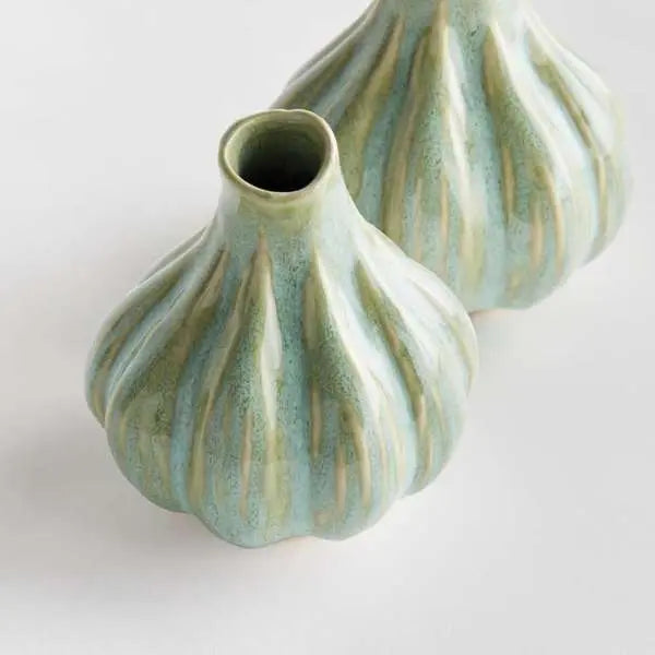 A set of two small round bud vases with a sculptural organic shape, finished in a thick multi-tonal green reactive glaze with handcrafted artisan details.