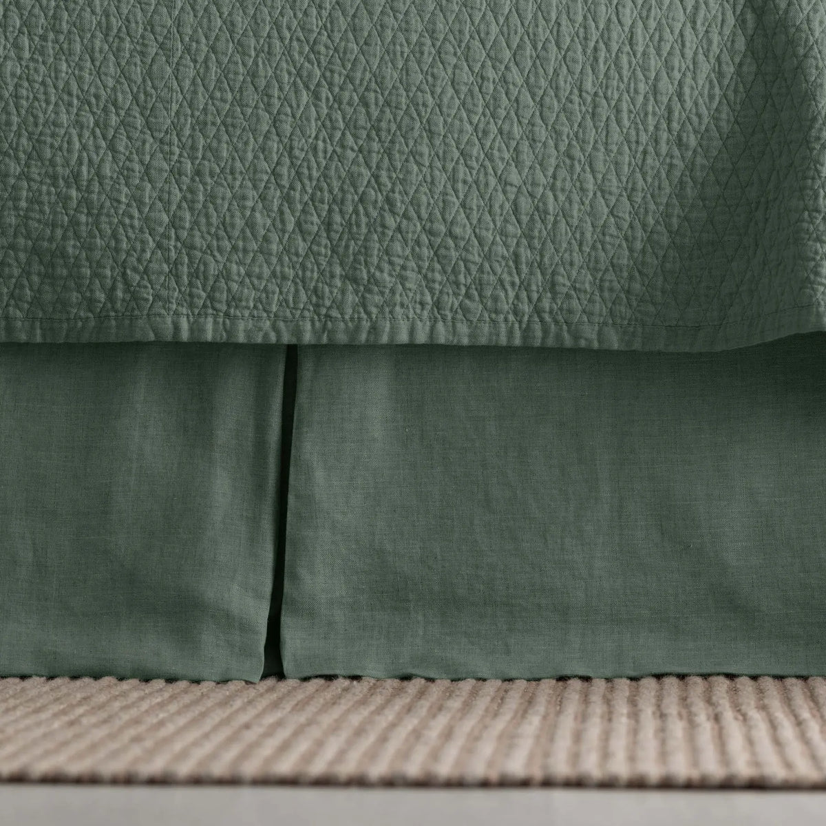 Dawn Tailored Bed Skirt in green, close-up on a bed frame